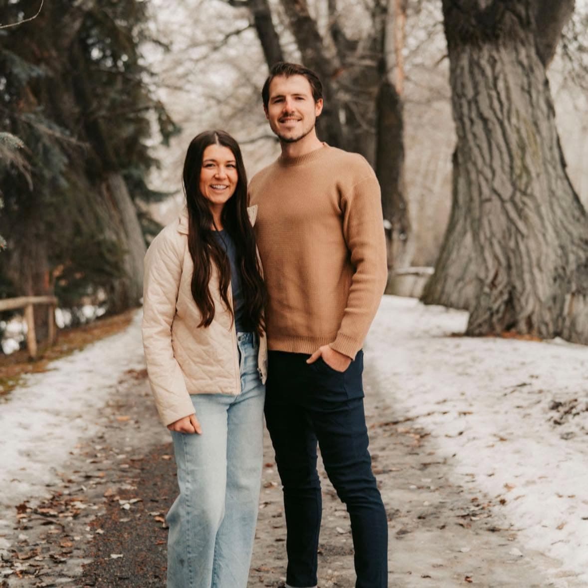 Brigham Redd and his wife on a snowy, tree-lined path